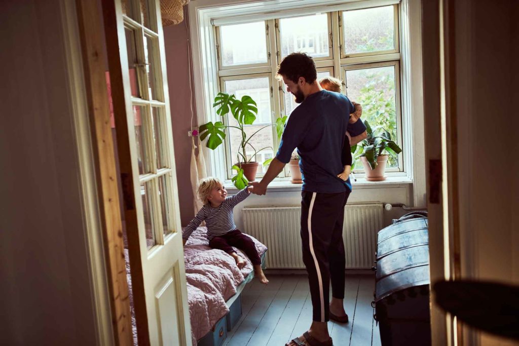 En enskild näringsidkare njuter av tid med hans två barn medan han arbetar hemifrån