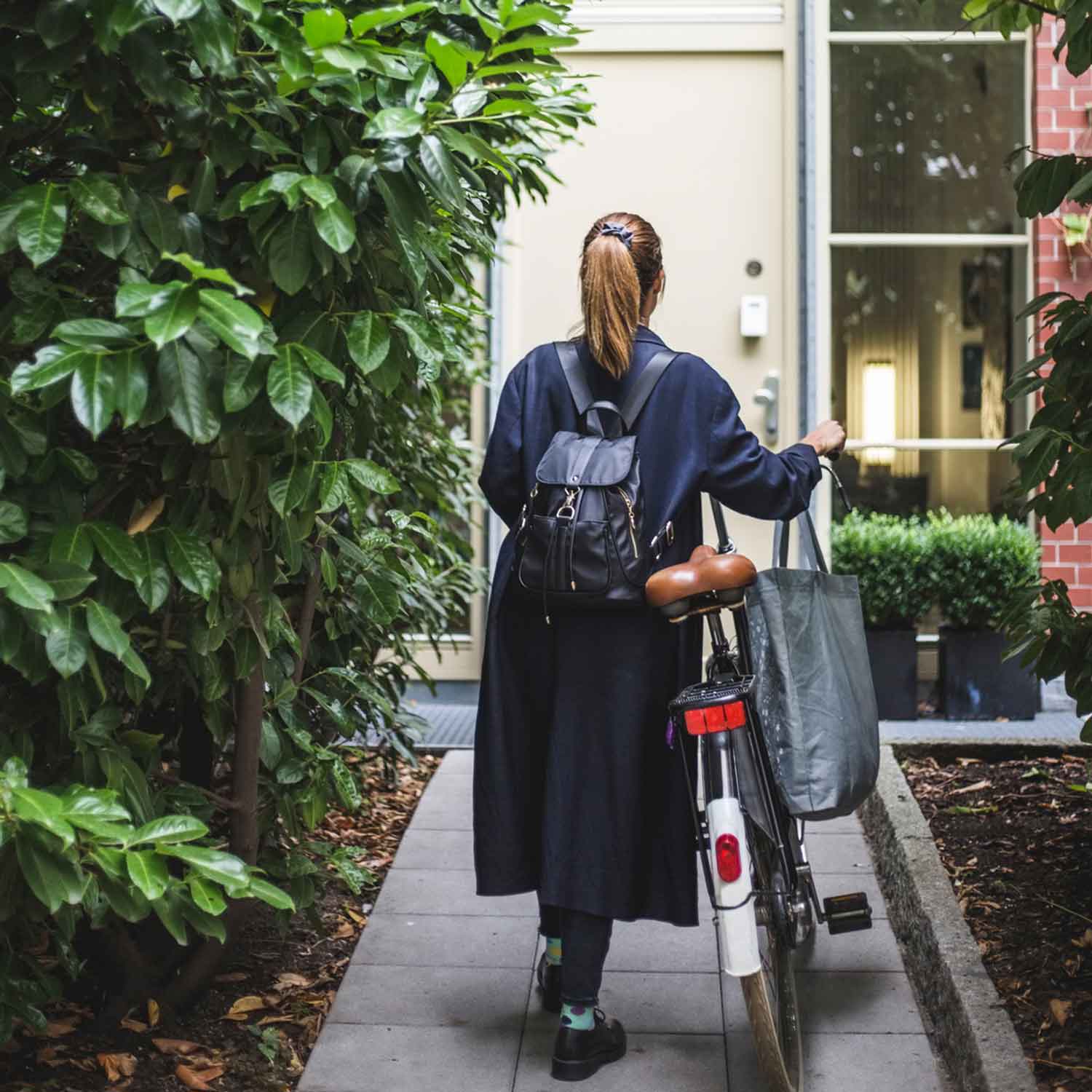 A sole trader arriving home with their bike